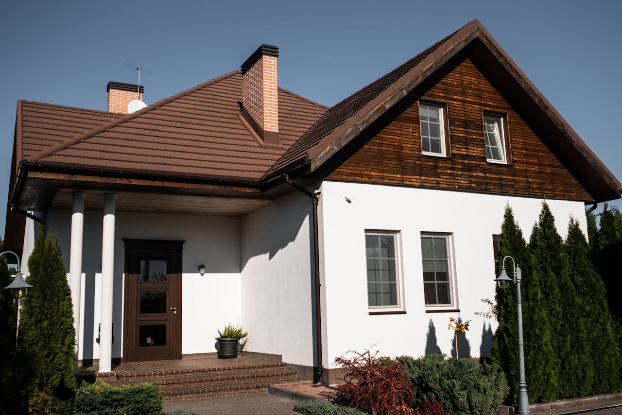 hero-img-01 Charming modern bungalow with white facade and brown roof, ideal for architectural themes.