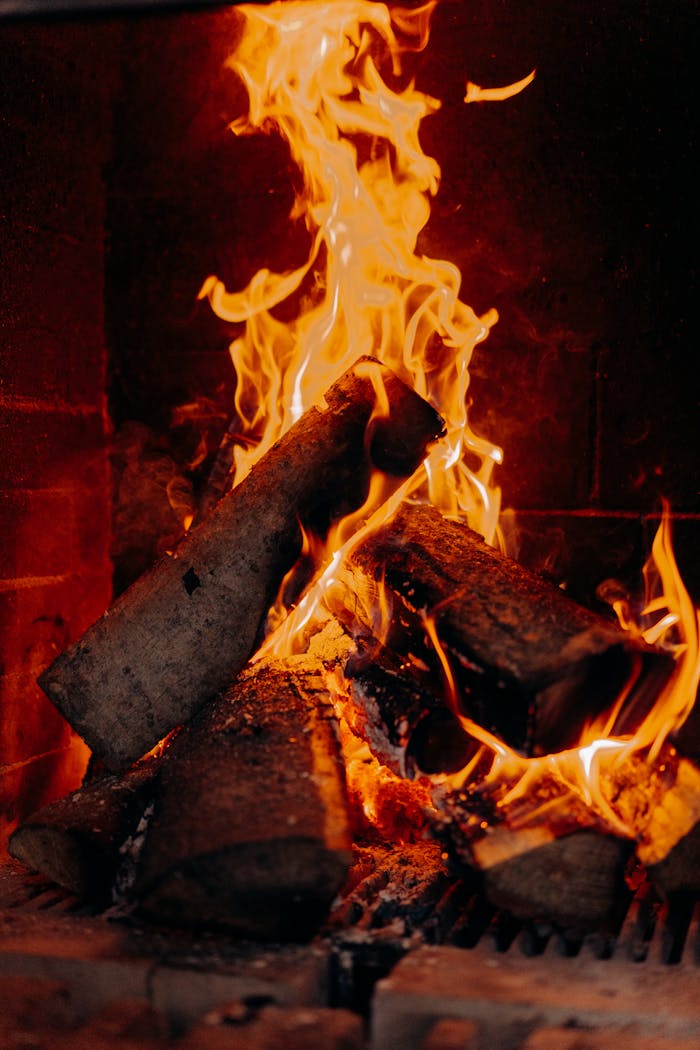Cozy fireplace with fiery logs indoors creates a warm ambiance.